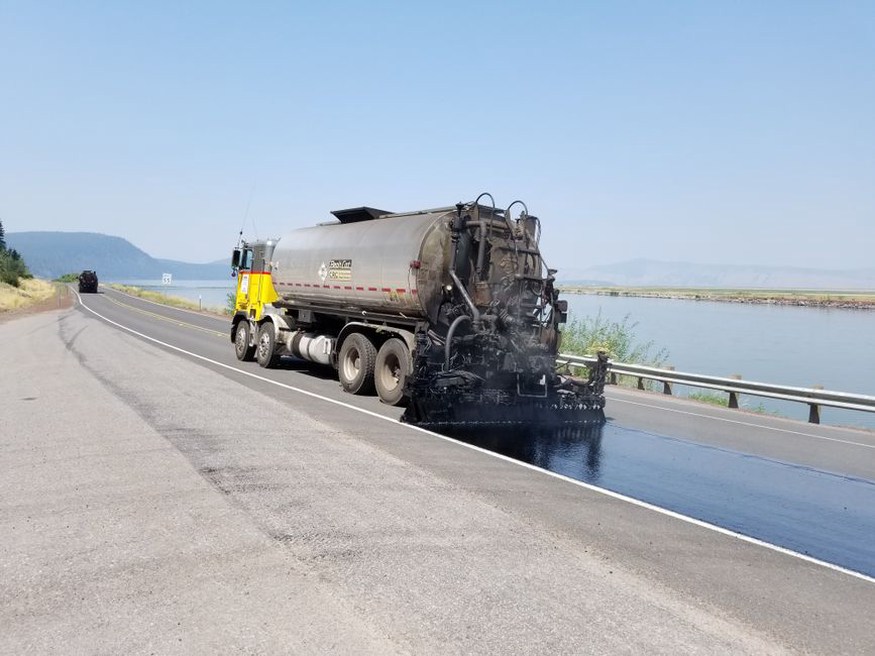 Workers applying recycled asphalt pavement on a road