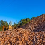 Separate reclaimed asphalt stockpiles beside a mixing plant