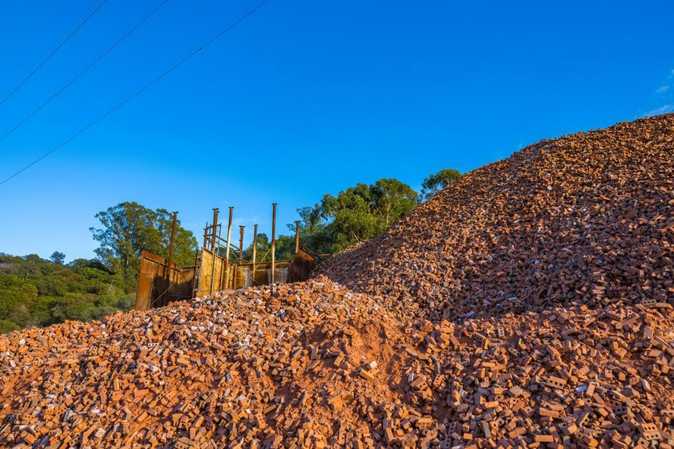 Separate reclaimed asphalt stockpiles beside a mixing plant