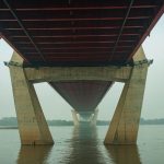Engineer checks a bridge bearing beneath the deck