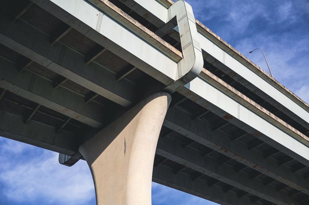 Engineer documenting defects beneath a concrete bridge