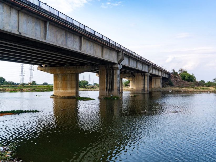 Engineers inspecting scour protection near a bridge abutment