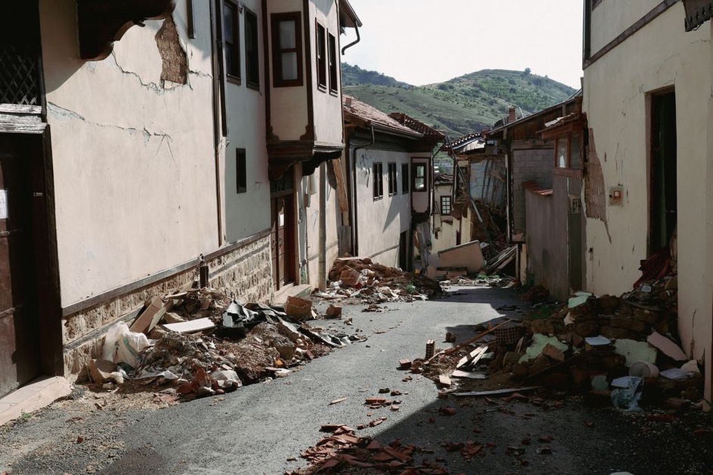 Uneven pavement beside a settled road shoulder