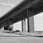 Inspector examining the underside of an elevated roadway