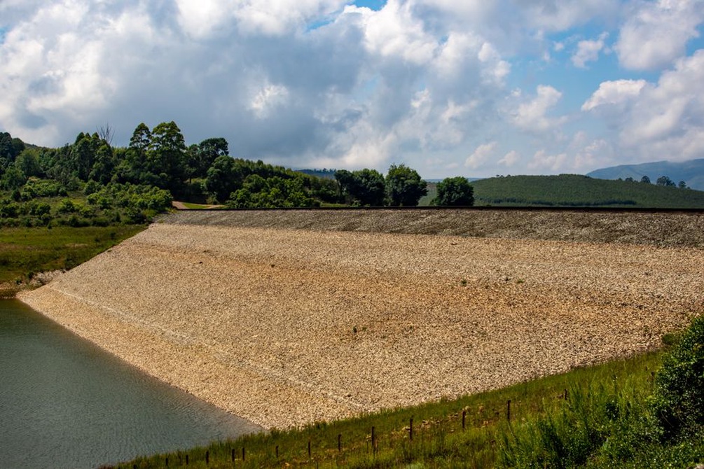 Engineer inspecting erosion beside a flooded rail embankment