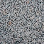Workers place geogrid over prepared road formation