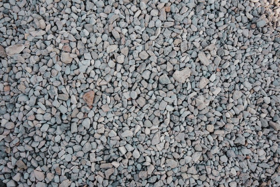 Workers place geogrid over prepared road formation