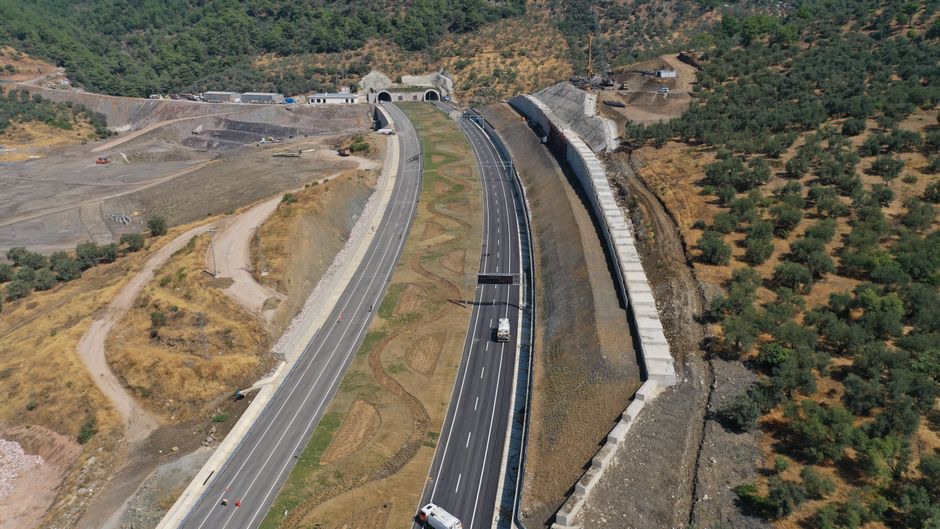 Engineers examining drainage and ground conditions on a road slope