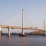 Slender bridge span framed by an urban river corridor