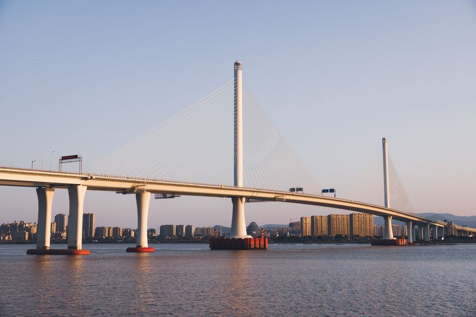 Slender bridge span framed by an urban river corridor