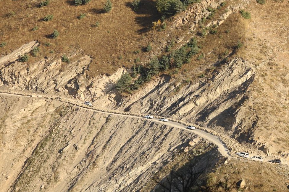 Engineer checks a debris barrier above a mountain road