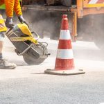 Engineers examining pavement cores beside a road