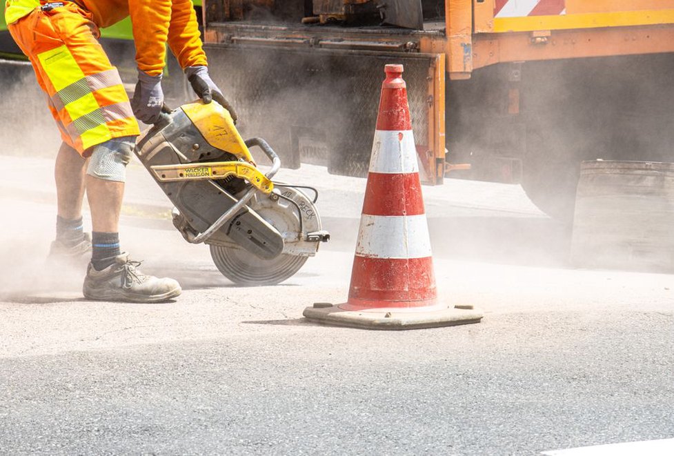 Engineers examining pavement cores beside a road