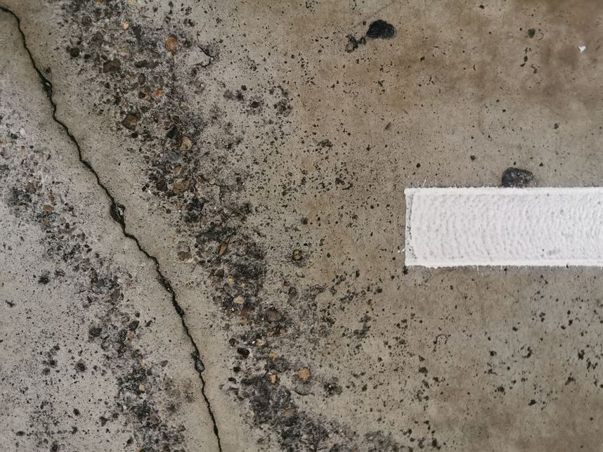 Technician assessing cracks and pavement response