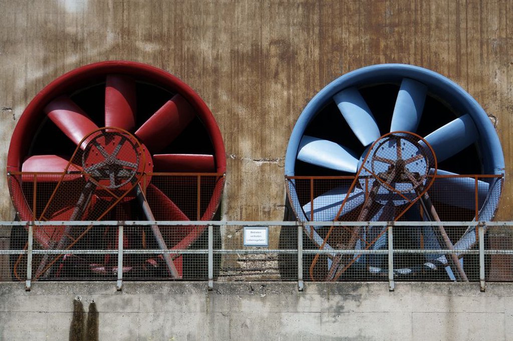Technician inspecting ventilation equipment in a tunnel service area