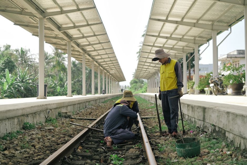 Inspectors checking drainage beside an elevated transit route