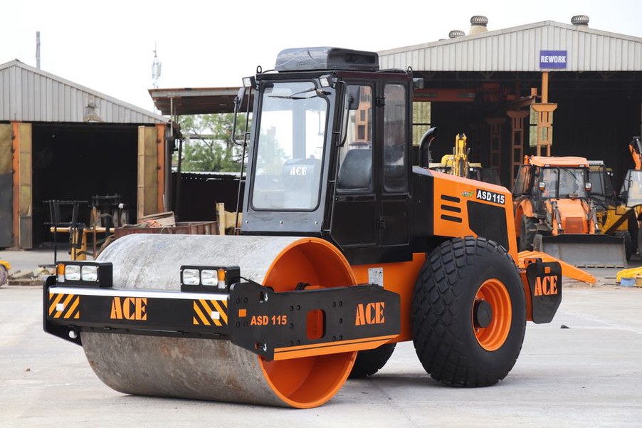 Workers using vibratory rollers for road construction