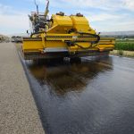 Roller compacting a freshly placed asphalt layer