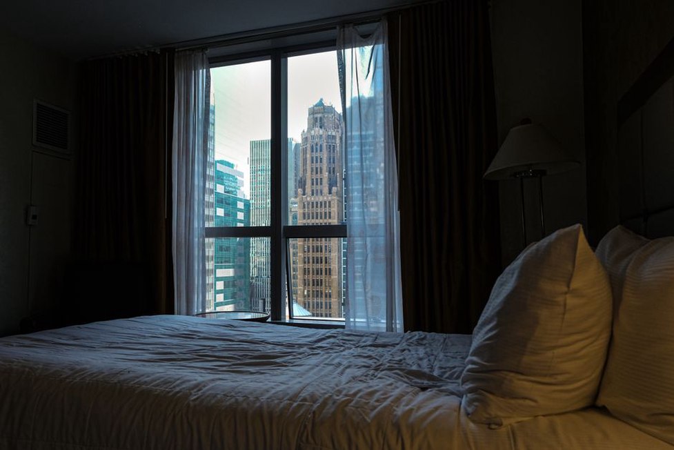 Closed curtains reduce light near the bed