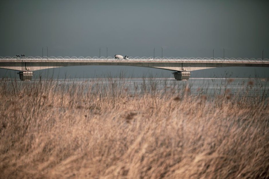 Bridge abutment adjoining a compacted approach embankment