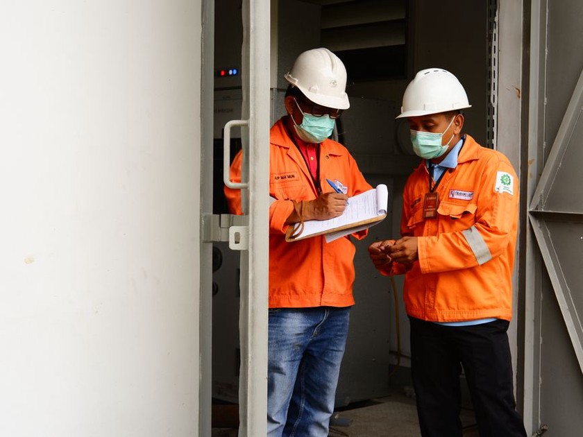 Engineers comparing measurements with field notes