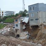 Engineers examine a settled bridge approach