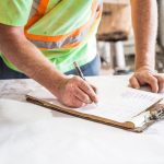 Engineer compares inspection records with bridge drawings