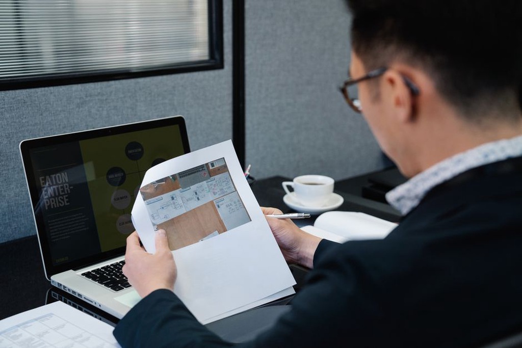 Engineer checks written feedback beside project documents
