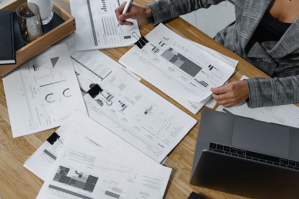 Engineer checks a technical document beside a laptop