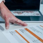 Audit records beside a technical article on screen