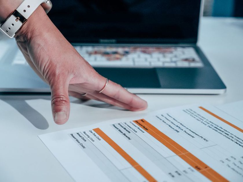 Audit records beside a technical article on screen