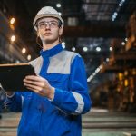 Inspector checks a digital bridge record outdoors