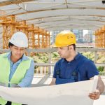 Two engineers check access points on a site map