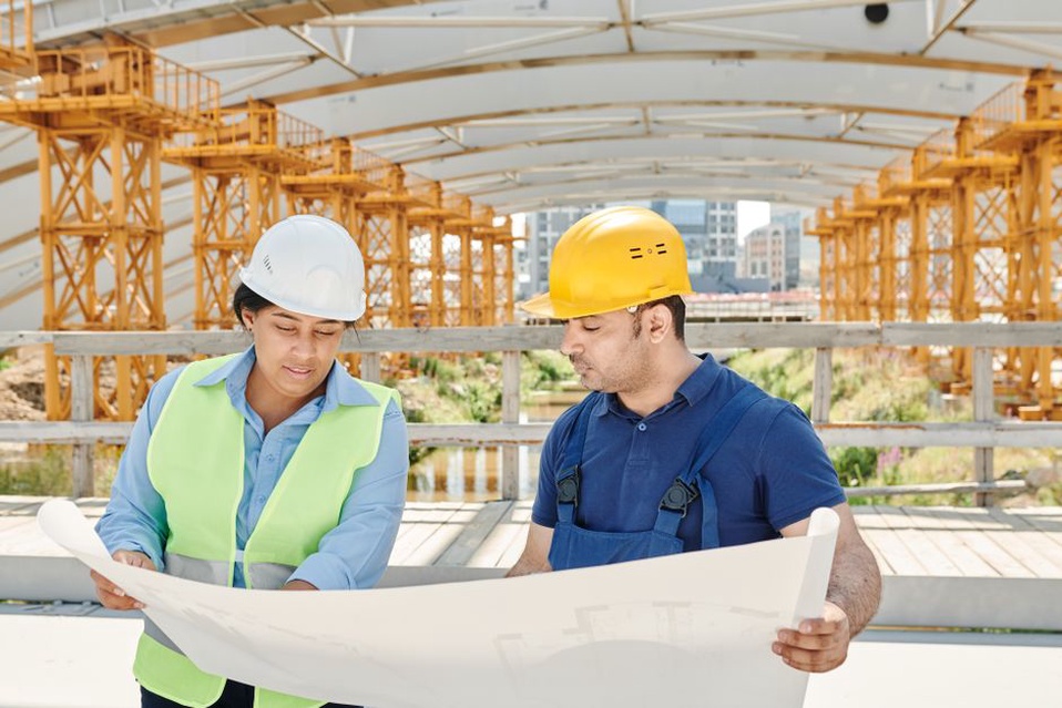 Two engineers check access points on a site map