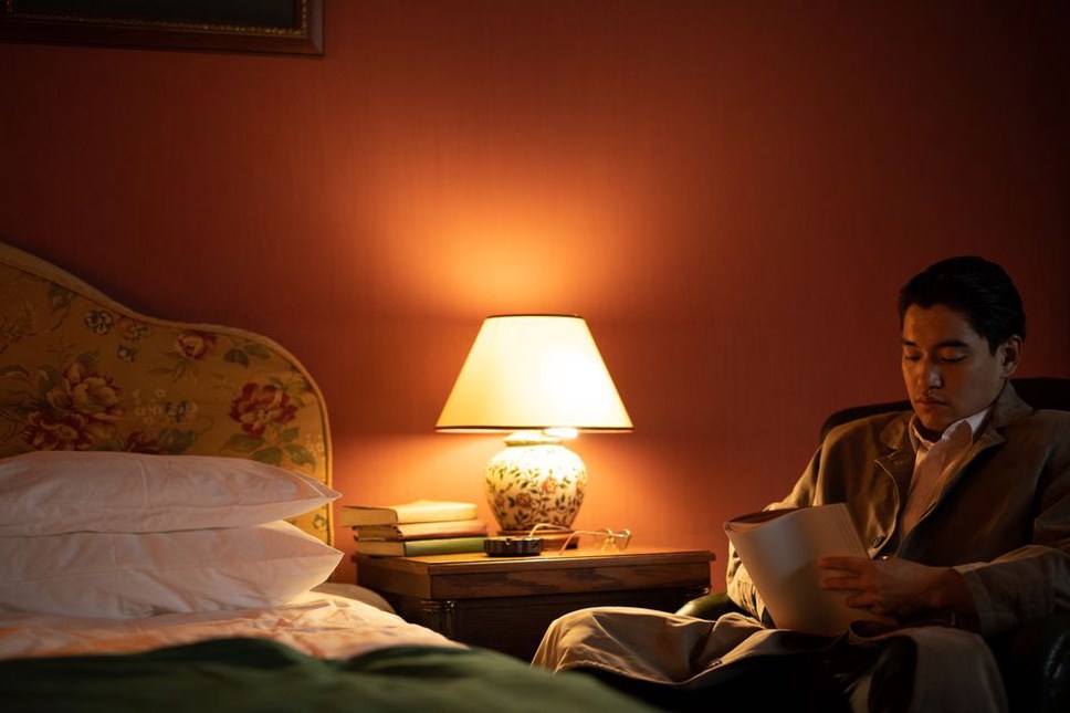 A closed notebook beside a dim evening lamp