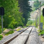 Technician checks instruments beside a railway embankment