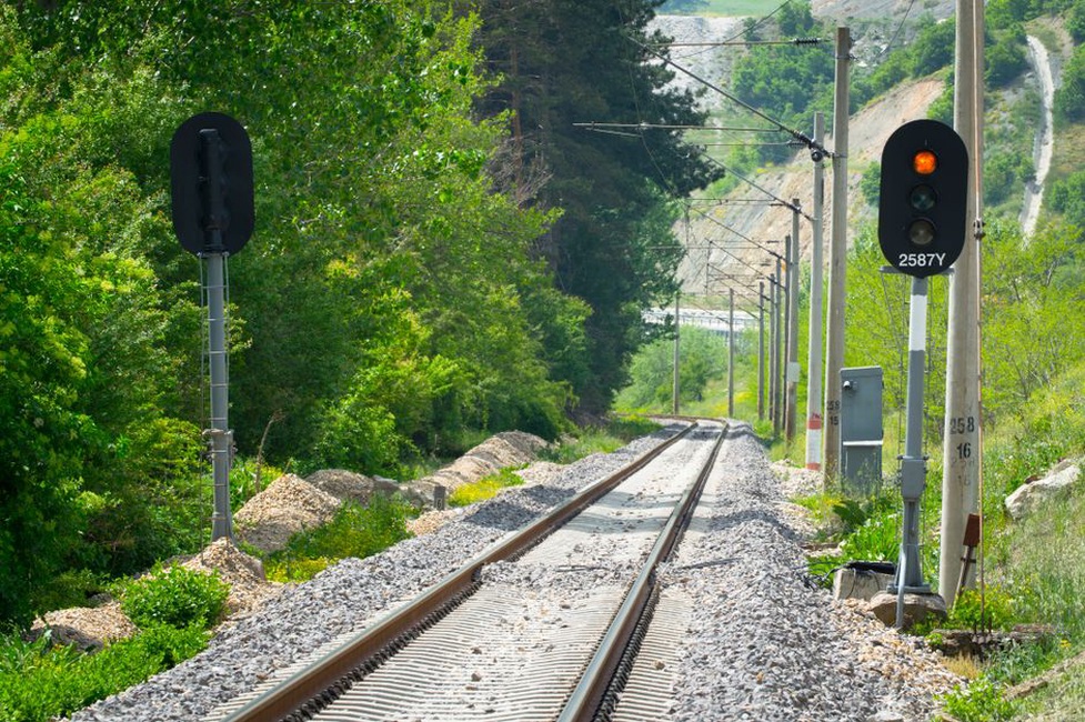 Technician checks instruments beside a railway embankment