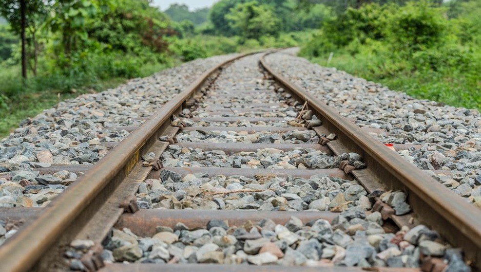 Surveyors check track alignment on an embankment