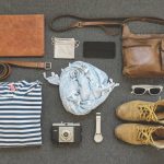 Two outfits arranged beside a compact travel bag