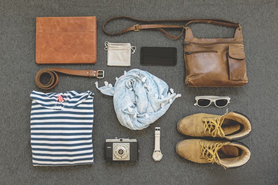 Two outfits arranged beside a compact travel bag